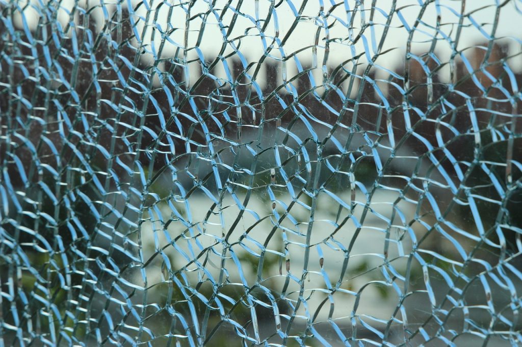 a window with spiderweb cracks of glass all over it, obscuring the view outside